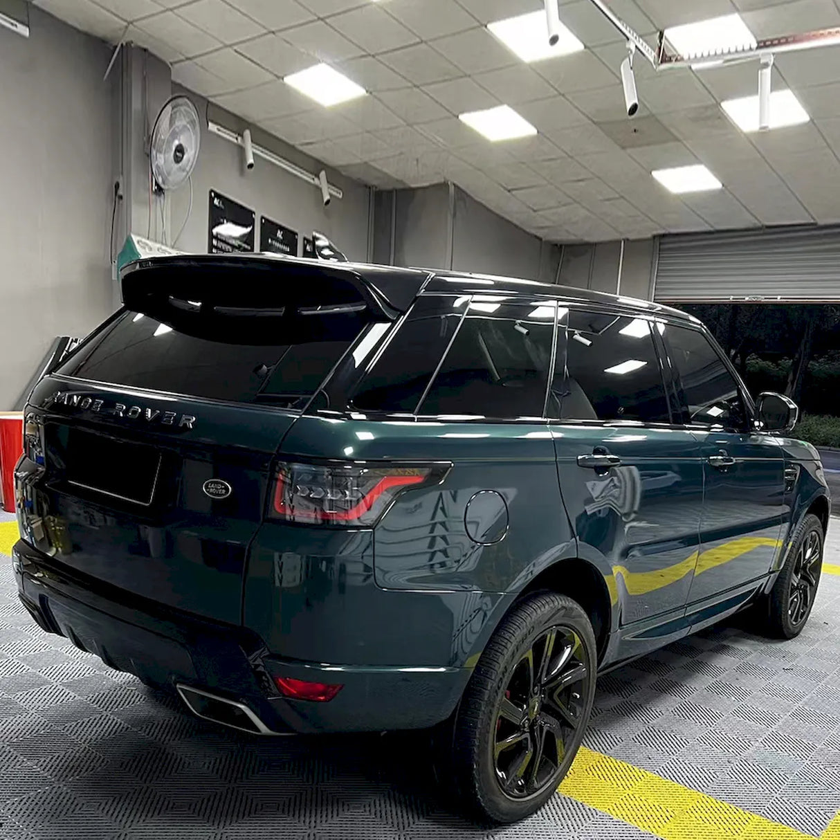blackish green car wrap being installed on a suv