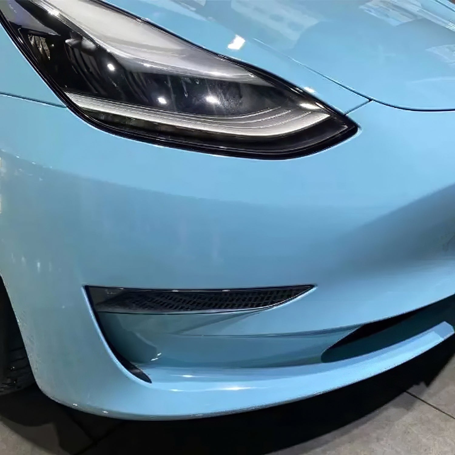 up close corner of a tesla model 3 wrapped in crystal sea breeze blue