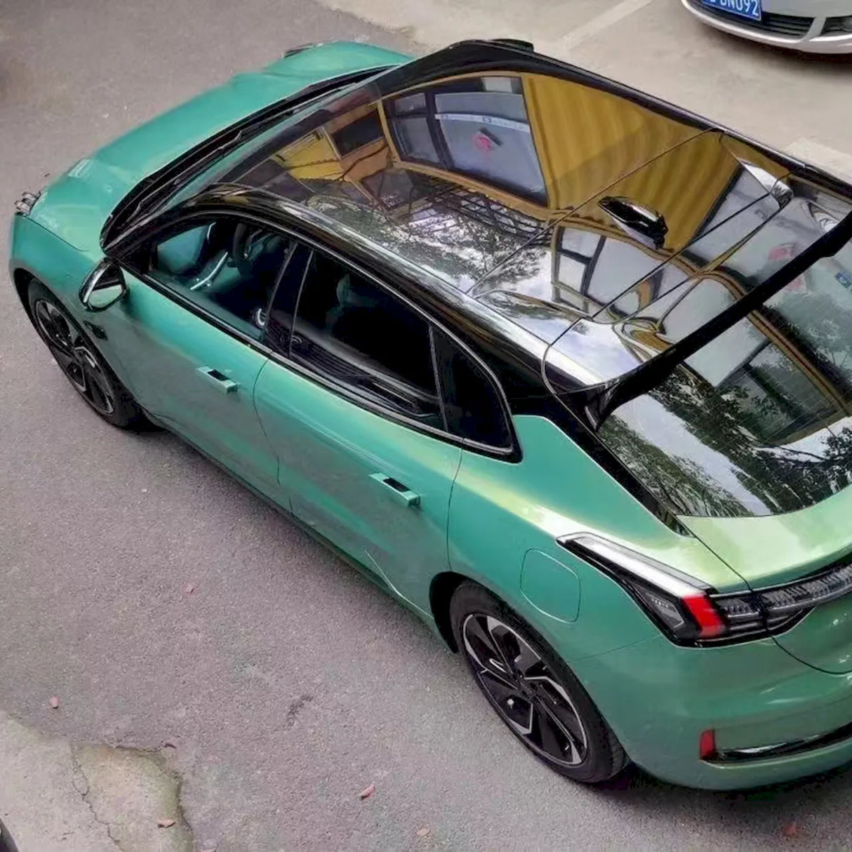 metallic rainbow green car wrap on a cloudy day