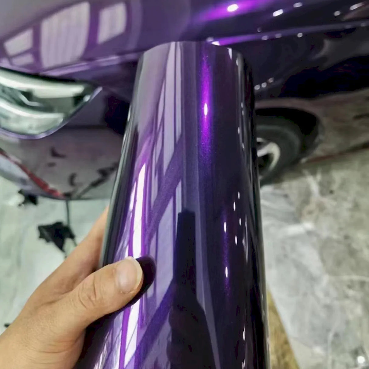 metallic venice purple vinyl wrap roll next to a car that is being wrapped