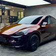 tesla with phantom red car wrap at a shop