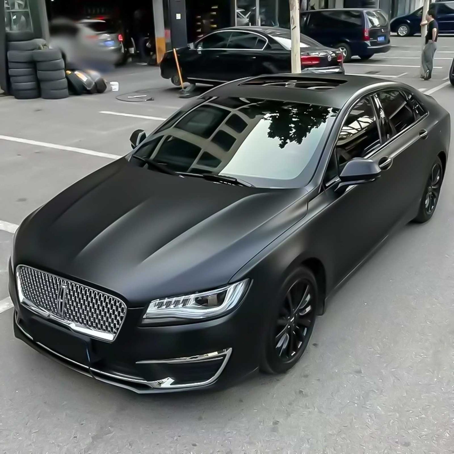 satin black vehicle wrap being shown on a 4 door lincoln