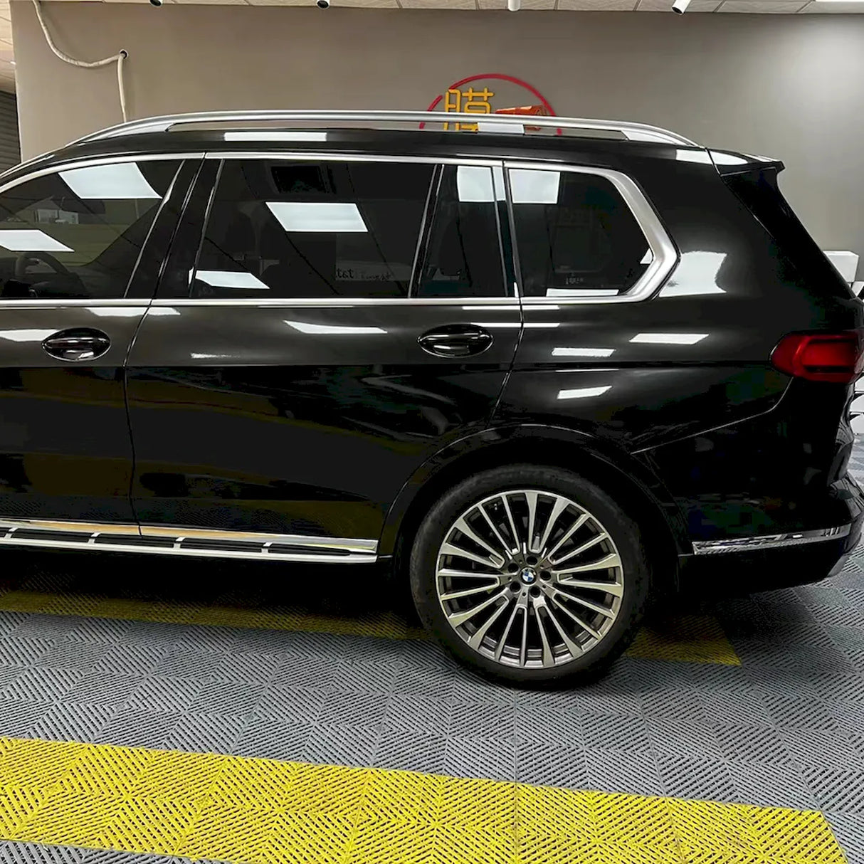 metallic black gold car wrapping vinyl being installed on a vehicle