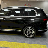 metallic black gold car wrapping vinyl being installed on a vehicle