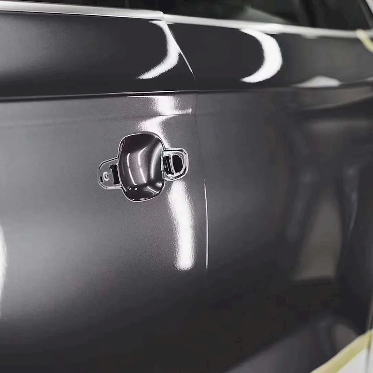 space gray metallic gloss car wrap being installed on a door panel